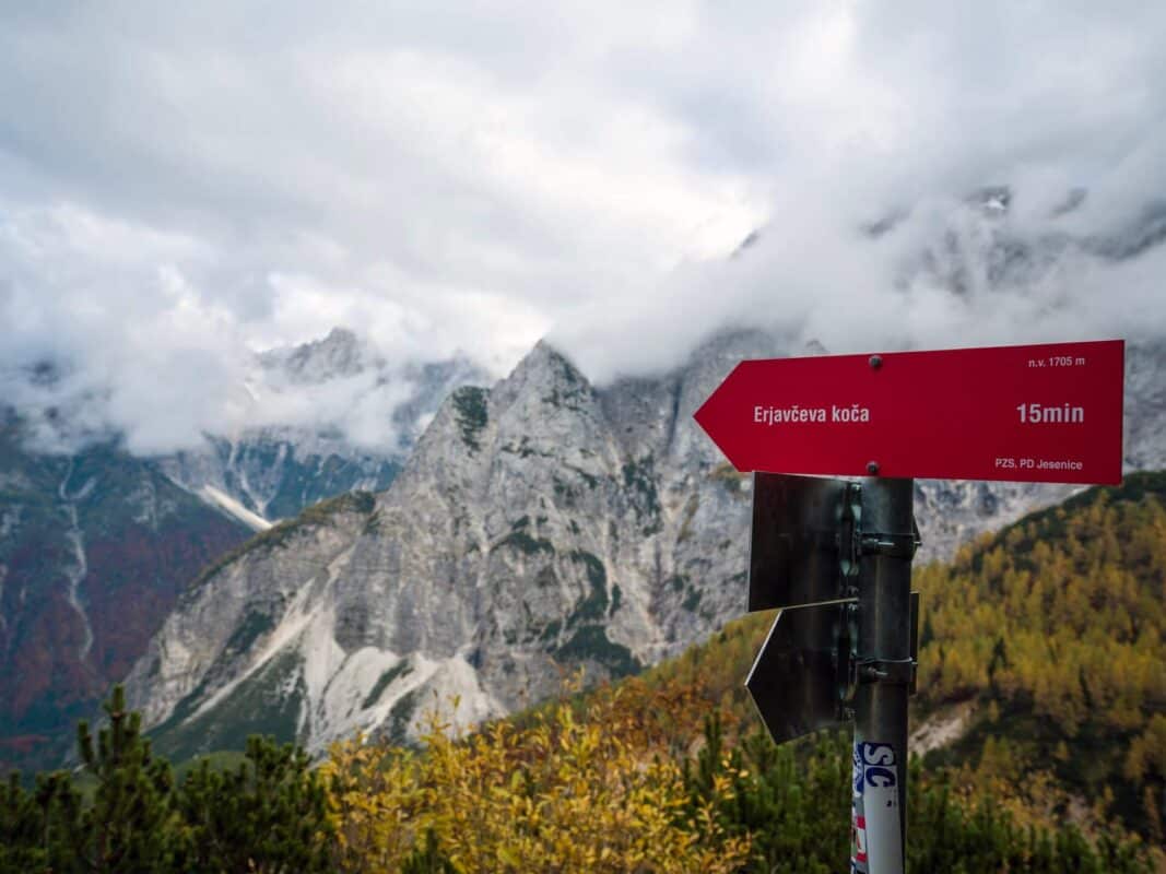 Paysage de montagne isolé avec des pics rocheux enveloppés de brouillard et des arbres aux couleurs automnales au refuge d'Erjavčeva.